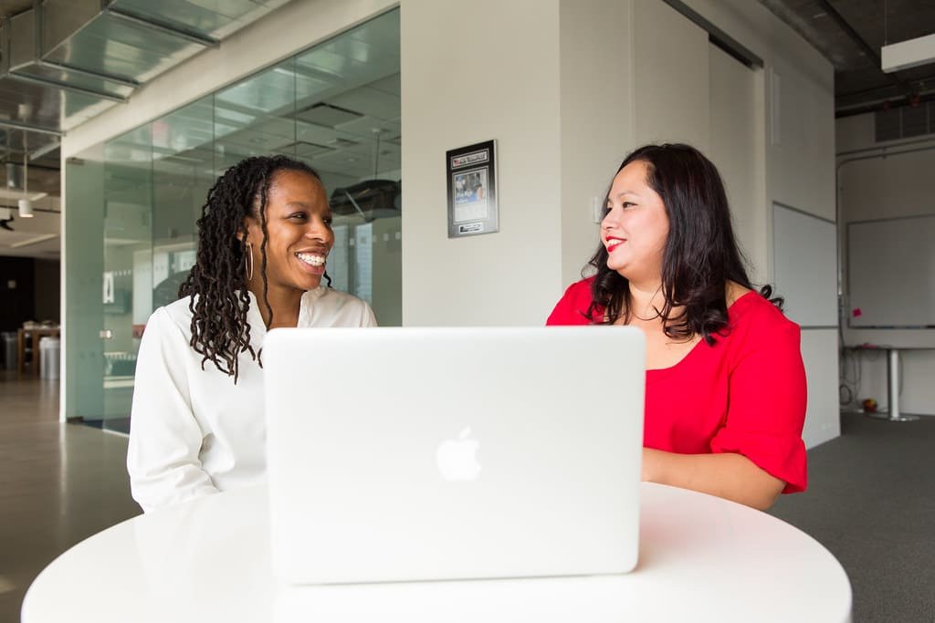 Advisor and client smiling together over a laptop